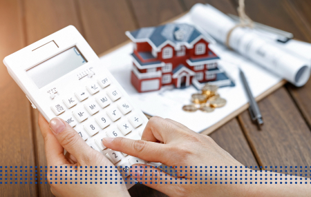 FIRST TIME BUYER LOAN, LAND LOANS & OTHER HOME LOANS - photo graphics person holding a calculator small house model pen coins clipboard