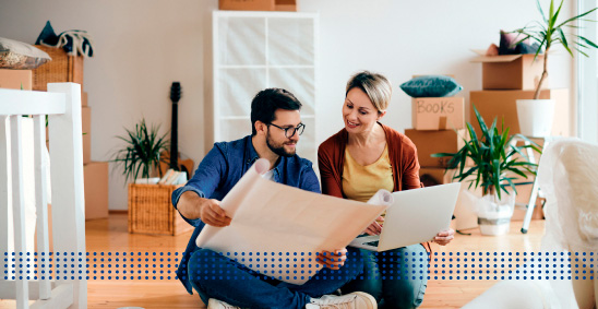HOME LOANS FOR FIRST TIME BUYERS - photo graphics couple sitting on floor holding building plans