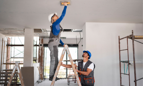 renovation goals - photo graphics 2 workers painting ceiling