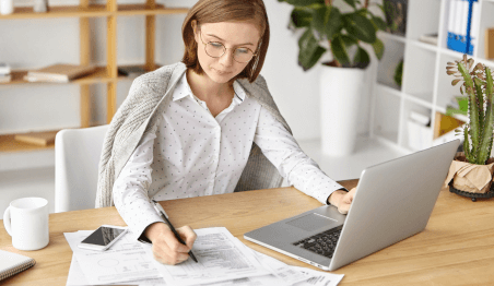 WHAT IS A WORKING CAPITAL LOAN - photo graphics woman using laptop writing on paper